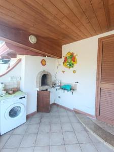 PERLA VERDE Rooms and parking في Case Nuove: مطبخ مع غسالة ملابس في الغرفة