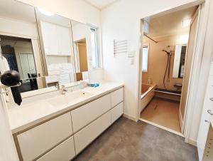 Un baño con lavabo y un espejo grande. en Osaka Lodge Midori - Designer House by Mitsui Home, en Sakai