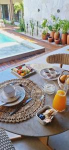 a table with plates of food and fruit on it at Be Caju Hotel in Barra Grande