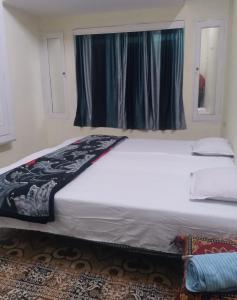 Postel nebo postele na pokoji v ubytování ganga kashi niwas