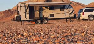 a camper is parked on a rocky road at مخيم السراي الشتوي in ‘Ibrī