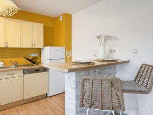 a kitchen with a counter and a chair in it at L'Ecrin - Spacieux & Garage Privé - Calme à 5minutes de Rennes in Pacé