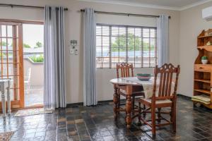 Un comedor con una mesa y dos sillas. en Summer House, en Harrismith 6 fotos más