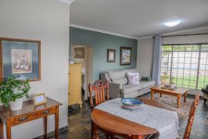una sala de estar con una mesa y un sofá en Summer House, en Harrismith