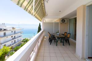 a balcony with a table and chairs and the ocean at Amadolia in Loutra Edipsou
