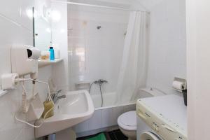 a white bathroom with a sink and a toilet at Amadolia in Loutra Edipsou +17 photos