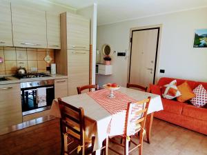 a kitchen and dining room with a table and a couch at Appartamento Verdenatura in Branzi