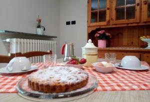 a table with a table cloth with a cake on it at Appartamento Verdenatura in Branzi