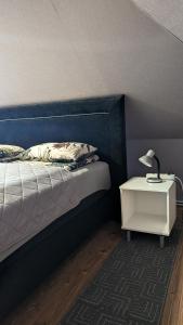 L apartamentai su nemokamu parkingu في شياولياي: غرفة نوم بها سرير وطاولة ومصباح +7 صور