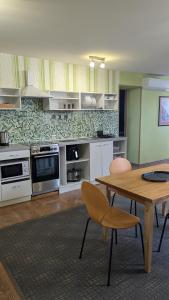 L apartamentai su nemokamu parkingu في شياولياي: مطبخ مع طاولة خشبية وطاولة وكراسي