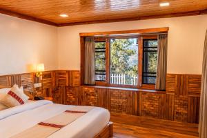 a bedroom with two beds and a window at WoodVista Cottages By Jomotel in Shimla