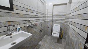 een badkamer met een wastafel en een toilet bij Deoghar BnB Homestay in Deoghar