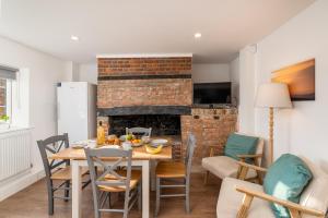 a dining room with a table and a fireplace at Wallace Hill Cottage - Garsington Studios - Pass the Keys in Stokenchurch