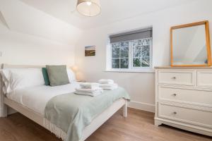 a bedroom with a bed with a dresser and a window at Wallace Hill Cottage - Garsington Studios - Pass the Keys in Stokenchurch +22 photos