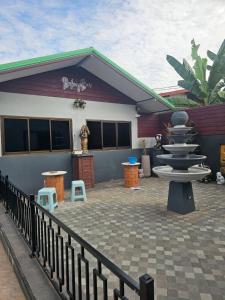 een gebouw met een patio met een fontein ervoor bij Saensuk stay in Ban Wang Thong