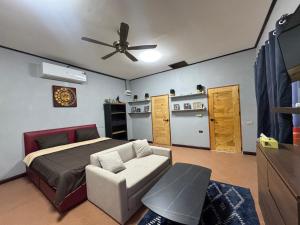 een slaapkamer met een bed en een plafondventilator bij Saensuk stay in Ban Wang Thong