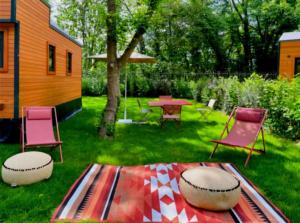 een achtertuin met een tafel en stoelen en een tafel met een deken bij Cabane 3 étoiles - ccbechc in Neuilly-sur-Marne