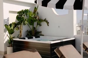 a bathroom with a black and white tub with plants at Apartamentos Islamar Arrecife in Arrecife +71 photos