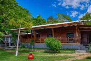 a wooden house with a red vase in front of it at Beach Villa l'Heure Bleue in Madirokely