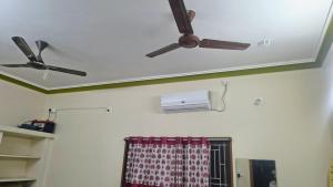 zwei Deckenventilatoren und eine Klimaanlage in einem Zimmer in der Unterkunft Aravindh's Chendur HomeStay in Tiruchchendūr