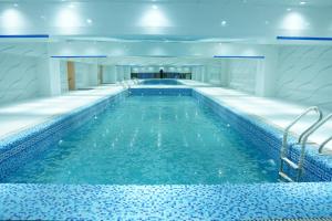 una piscina con agua azul en un edificio en Amanah Serviced Apartments, en Lahore