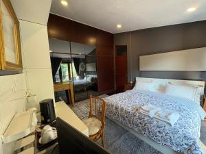 a bedroom with a bed and a desk and a television at Narra House Sukhumvit58 in Bangkok