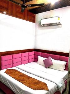 une chambre avec un lit rose et blanc avec des oreillers dans l'établissement Hotel Golden Time, à Karnal