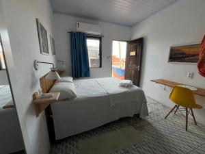 Un dormitorio con una cama y una silla amarilla. en Casa Guarnicê Hostel, en São Luís