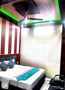 une chambre avec un lit avec une lumière verte dans l'établissement Hotel Golden Time, à Karnal