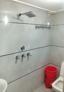 une salle de bain avec toilettes et poubelle rouge dans l'établissement Hotel Golden Time, à Karnal