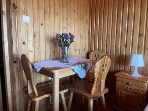 a table and two chairs with a vase of flowers on it at DW Łomnica in Białka Tatrzańska