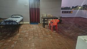 Zimmer mit einem Tisch, einem Tisch und Stühlen in der Unterkunft Aravindh's Chendur HomeStay in Tiruchchendūr