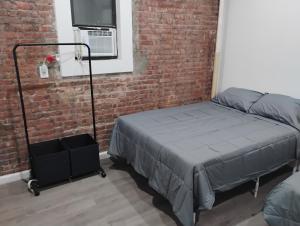 Aycee 417 في نيويورك: غرفة نوم بها سرير وجدار من الطوب