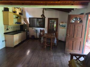 eine Küche und ein Esszimmer mit einem Tisch und einem Kühlschrank in der Unterkunft pileta,quincho,parque hasta 8 personas cerca panamericana, mascotas no fiestas, con seña únicamente, confirmar x mensaje de whatsap in Grand Bourg