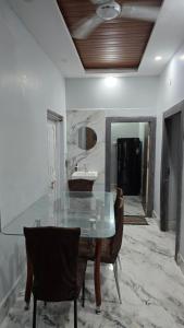 een eetkamer met een glazen tafel en stoelen bij Deoghar BnB Homestay in Deoghar