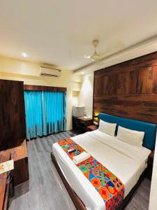 ムンバイにあるHotel AI inのベッドルーム1室(大型ベッド1台、青いヘッドボード付)