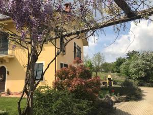 a house with a flowering tree in front of it at Il cotogno in Carrosio