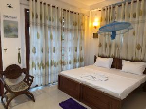 a bedroom with a bed and a chair and a window at JJ Villa & Tours in Aluthgama