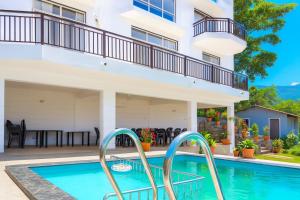 una piscina di fronte a una casa con balcone di Hemgiri - Luxury 6BHK Private Pool Villa, Dam & Valley Views, Girivan Mulshi a Mulshi Altre 17 foto