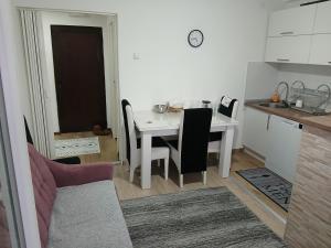 a kitchen with a white table and a table and chairs at Novi Priboj in Čitluk