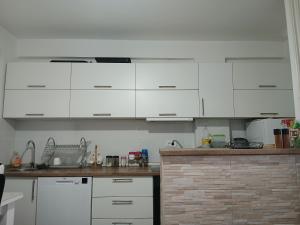 a kitchen with white cabinets and a counter top at Novi Priboj in Čitluk +9 photos