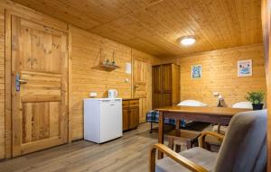 Gorgeous Home In Ruciane - Nida في روسيان-نيدا: مطبخ مع ثلاجة وطاولة في كابينة +6 صور