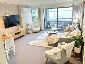 Una sala de estar con un sofá y un televisor. en Luxury Oceanfront Unit - Cumberland Lorne Resort, en Lorne