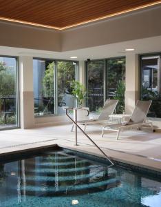 una piscina con 2 sillas y una mesa junto a un edificio en Luxury Oceanfront Unit - Cumberland Lorne Resort, en Lorne