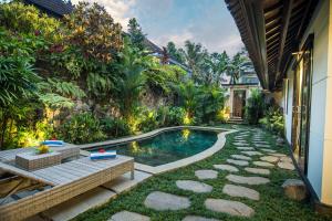 a swimming pool in the middle of a garden at Wardana Ubud Villa I in Ubud