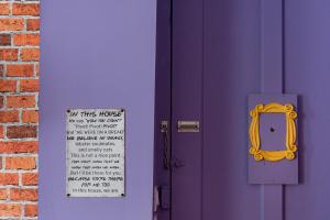 eine lila Tür mit einem Schild daran und einem Fenster in der Unterkunft Appartement immersif - ambiance série TV in Saint-Étienne