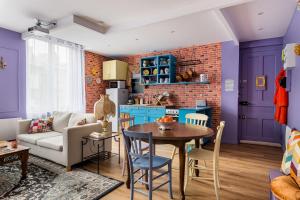 eine Küche und ein Wohnzimmer mit einem Tisch und einer Couch in der Unterkunft Appartement immersif - ambiance série TV in Saint-Étienne