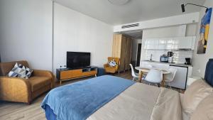a living room with a bed and a kitchen at Студия в White Sails видовая in Batumi