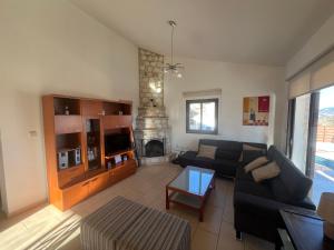 Una sala de estar con un sofá y una chimenea. en Afroditi House, en Stroumbi
