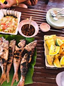 a table with fish and rice and other foods at Diapila baybayon Sunset View in El Nido